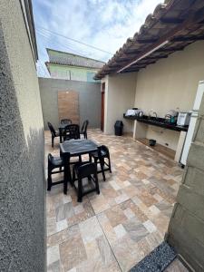a patio with a table and chairs on a tiled floor at Recanto Praia Grande in Arraial do Cabo