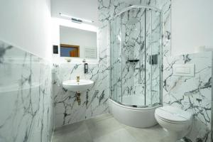 a bathroom with a shower toilet and a sink at City Tour Apartamenty in Poznań