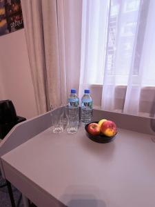 a table with two bottles of water and a bowl of fruit at City Tour Apartamenty in Poznań +77 photos