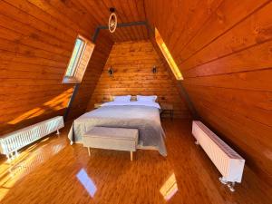 a bedroom in a log cabin with a bed at Twin Cabins Azuga in Azuga