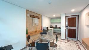 a kitchen with a glass table and chairs in a room at Duplex com Banheira no Centro de Campo Grande in Campo Grande
