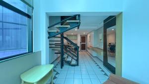 a staircase in a room with a bench and a table at Duplex com Banheira no Centro de Campo Grande in Campo Grande