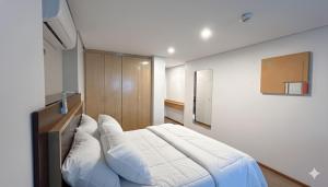 a bedroom with a large bed with white pillows at Duplex com Banheira no Centro de Campo Grande in Campo Grande +9 photos
