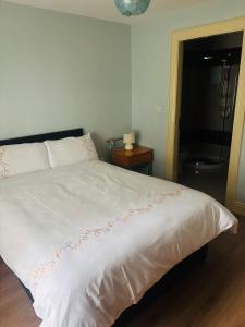 a bedroom with a white bed with a red decoration on it at Town Apartment in Ardara