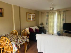 a dining room with a table and chairs and a bedroom at Town Apartment in Ardara