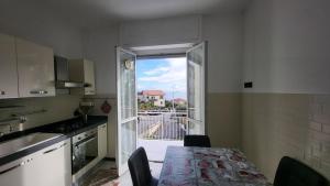a kitchen with a table and a large window at Vista dai pini in Varazze +25 photos