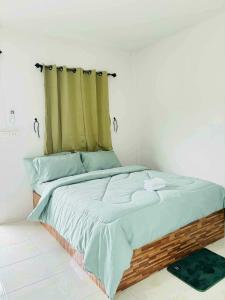 a bedroom with a bed with a green curtain at ไสวรีสอร์ท Sawai Resort in Ban Khao Noi