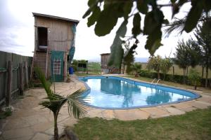 a swimming pool in a yard next to a house at Mambo Game View in Elmenteita
