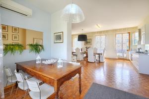 a living room with a wooden table and white chairs at Casamia Tuscan Oasis 4Br Panoramic Penthouse Hot Tub & Easy Parking in Siena