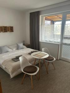 a bedroom with a bed and two chairs and a table at Privat Alfa in Hrabušice