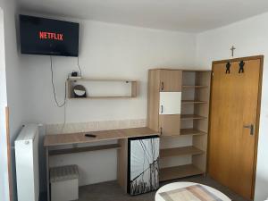 a room with a desk and a shelf and a tv at Privat Alfa in Hrabušice