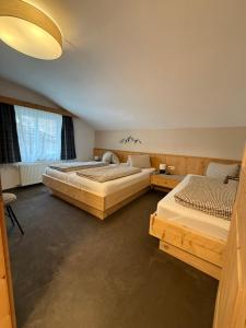 a bedroom with two beds and a large window at Appartement Schmid in Oetz