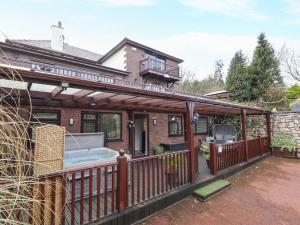 a house with a hot tub on a deck at Acorns in Holywell