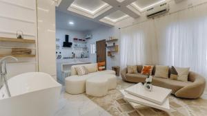 a white living room with a tub and a couch at French quarters apartments in Alaguntan +14 photos