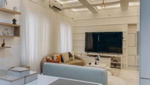 a living room with a couch and a large tv at French quarters apartments in Alaguntan