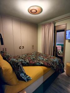 a bedroom with a bed with a colorful blanket at Sandy's Superior Suite in Ancient Epidauros