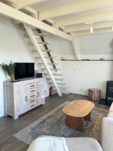 a living room with a couch and a table at Het schapenhuisje in Herkingen