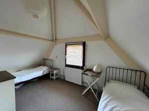 a room with two beds and a window at Het schapenhuisje in Herkingen
