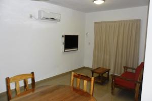 a living room with a table and chairs and a tv at Urunday Apart Hotel in Posadas