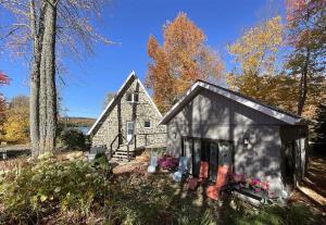 a small house with red chairs in front of it at Chalet Spa - La Détente au Mont-Comi in Saint-Gabriel