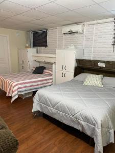 two beds are in a room with wooden floors at Chalet Spa - La Détente au Mont-Comi in Saint-Gabriel