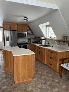 a large kitchen with wooden cabinets and a counter top at Chalet Spa - La Détente au Mont-Comi in Saint-Gabriel