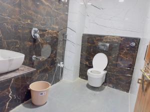 a bathroom with a white toilet and a sink at Hotel Paradise in Rewa