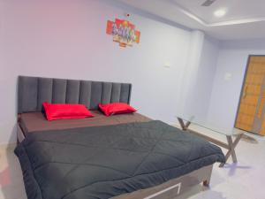 a bedroom with a large bed with red pillows at Hotel Paradise in Rewa