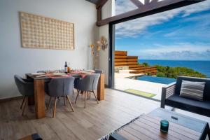 a dining room with a table and a view of the ocean at Luxury Oceanfront Villa Heated Infinity Pool in Petite Île