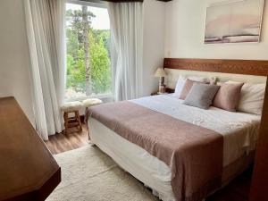 a bedroom with a large bed and a window at Suíte Refúgio Mountain Village Laje de Pedra 3003 in Canela