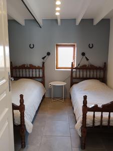 a bedroom with two twin beds and a table at Gîte FABEL HAUT in Durfort