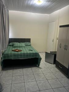 a bedroom with a green bed in a room at pousada irmãs in Pindamonhangaba +10 photos