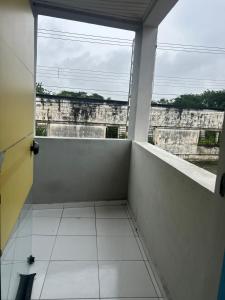 an empty room with a window and a white tile floor at pousada irmãs in Pindamonhangaba