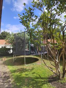 a swing set in a park with a tree at Agréable maison bien située in Capbreton