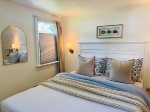 a bedroom with a bed with pillows and a mirror at Cape Cod Retreat, Osterville Beach Pass in Osterville