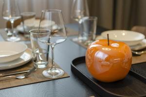 an orange apple sitting on a table with glasses at Dolomiten Apartments in Tesero