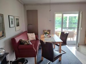 a living room with a table and a red chair at Ferienhäuschen blauer See in Bockhorn