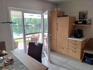 a kitchen with a table and a sliding glass door at Ferienhäuschen blauer See in Bockhorn