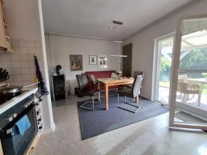 a kitchen and dining room with a table and chairs at Ferienhäuschen blauer See in Bockhorn +12 photos