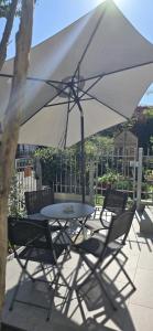 a table and chairs under a white umbrella at La Casina di Luca in Rimini