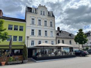 ein großes weißes Gebäude mit einem Sonnenschirm davor in der Unterkunft Maxplatz in Rehau