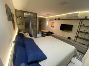 a bedroom with a large bed with blue pillows at Flat Vert House in João Pessoa