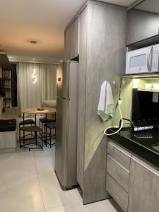 a kitchen with a refrigerator and a table with chairs at Flat Vert House in João Pessoa