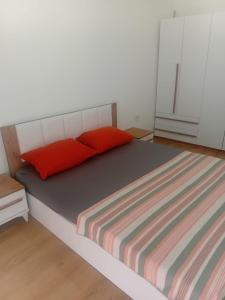 a bed with two red pillows in a room at Pristhine Stay Inn 19 in Prishtinë