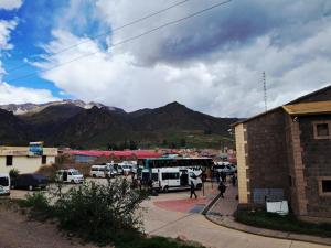 a group of buses parked in a parking lot with mountains at Belen Achomani in Chivay
