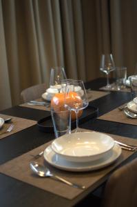 a table with plates and glasses on top of it at Dolomiten Apartments in Tesero