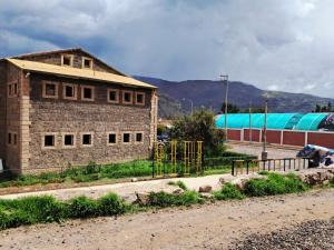a brick building on the side of a road at Belen Achomani in Chivay