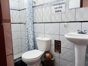 a small bathroom with a toilet and a sink at Belen Achomani in Chivay