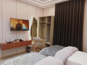 a bedroom with a bed and a tv on the wall at El Mandara Residence Inn in Alexandria