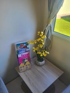 a table with a vase of flowers and a window at Nidd Way Holiday Let in Knaresborough